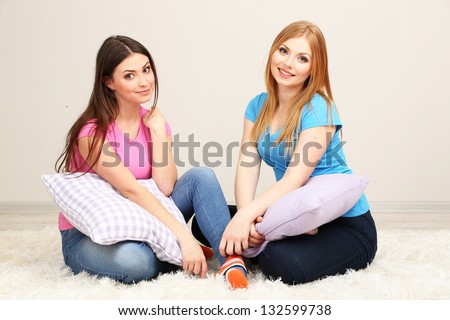 Two girl friends smiling on room