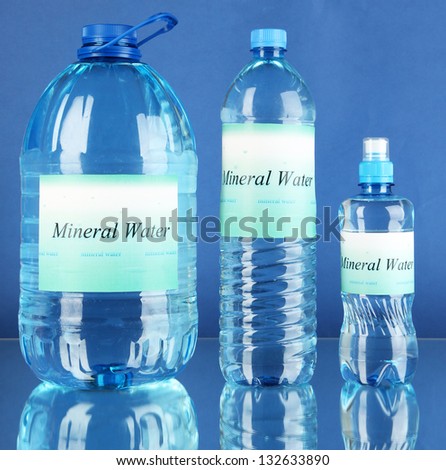 Different water bottles with label on blue background