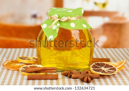 Jar of honey and dried lemon slices on bright background