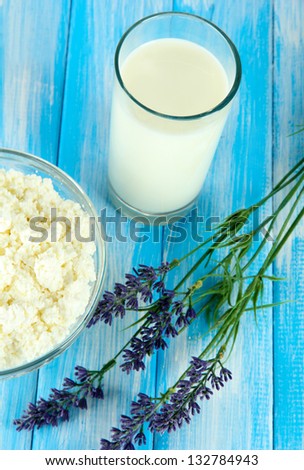 Glass of milk and cheese on a blue wooden table