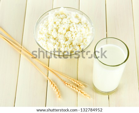 Milk and cheese, on a light wooden table