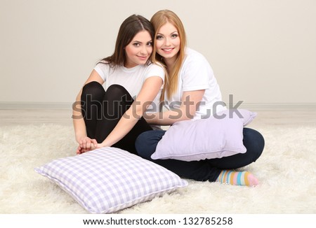 Two girl friends smiling on room
