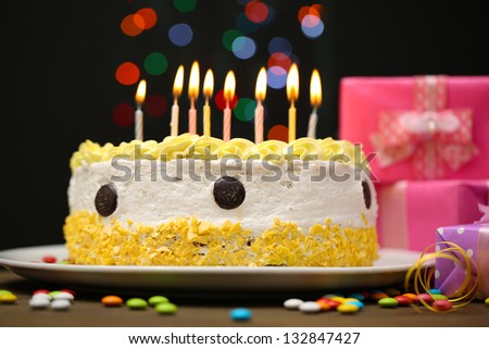 Happy birthday cake and gifts, on black background