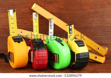 Tape measure and ruler on wooden background