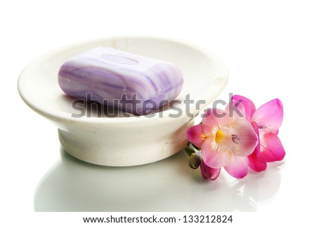 Soap-dish with soap and flower isolated on white