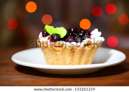 Tasty blackberry cake on dark background with bokeh  defocused lights