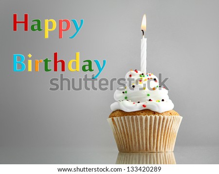 Tasty birthday cupcake with candle, on grey background