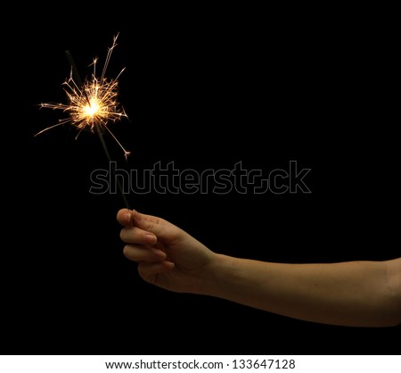 beautiful sparkler in woman hand on black background