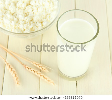 Milk and cheese, on a light wooden table