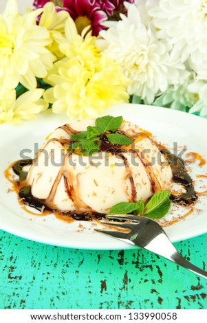 Panna Cotta with chocolate  and caramel sauces, on color wooden background