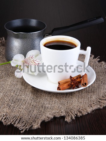White cup of Turkish coffee with coffee maker on wooden table