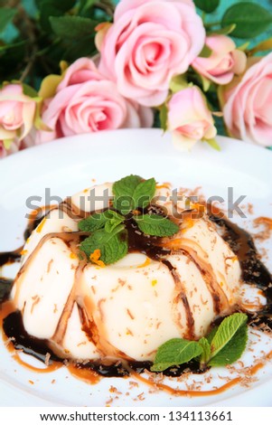 Panna Cotta with chocolate  and caramel sauces, on color wooden background