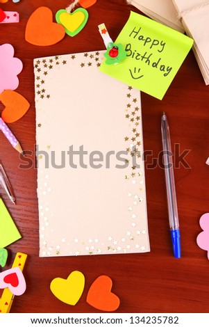 Writing letter of congratulations to Happy Birthday on wooden table close-up