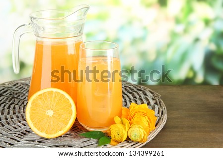 Glass And Pitcher Of Orange Juice On Wooden Table, On Green Background