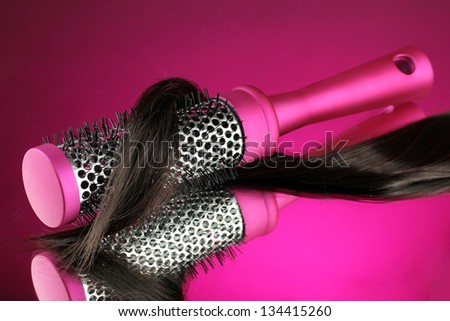 Comb brush with hair on purple background