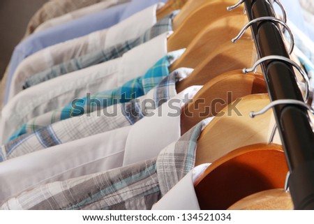 Men\'s shirts on hangers on gray background