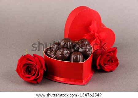 Chocolate candies in gift box, on grey background
