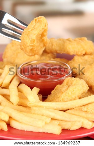 Fried chicken nuggets with french fries and sauce on table in cafe