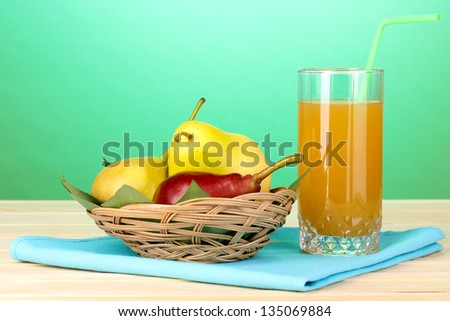 Pear juice with pears on wooden table on blue background