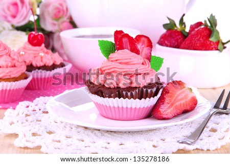 Beautiful strawberry cupcakes on dining table close-up