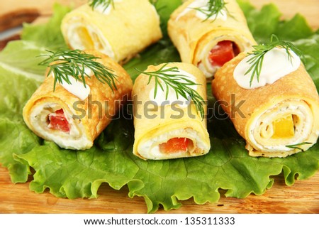 Egg rolls with cheese cream and paprika, on wooden board, close up