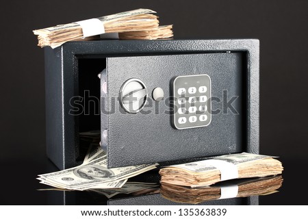 Money in open safe isolated on black