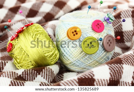 Buttons of different colors, and the two tangle thread on checked plaid