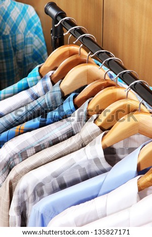 Men\'s shirts on hangers in wardrobe