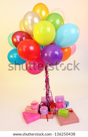 Many bright balloons and many gifts on light background