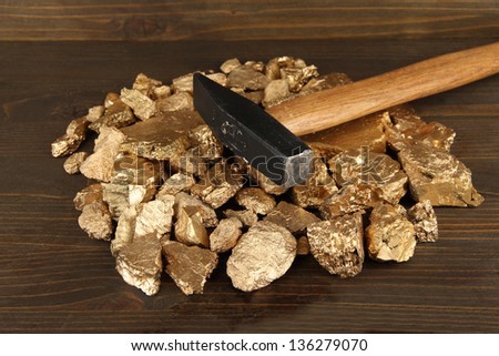 Golden nuggets with hummer on wooden background