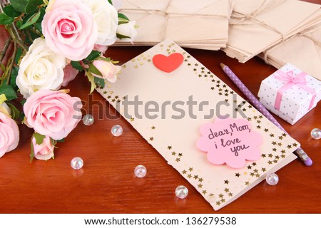 Writing letter of congratulations to mother\'s Day on wooden table close-up