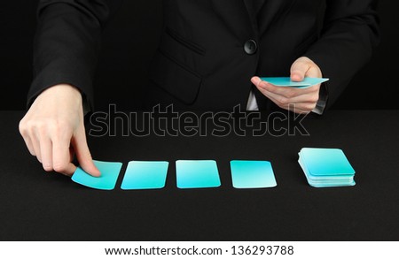 Hand with business cards. Concept: Business like poker game. Isolated on black