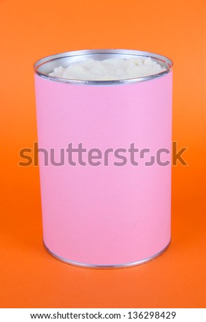 Powdered milk for baby on orange background