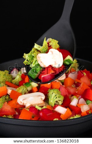 Vegetable ragout in pan, isolated on black