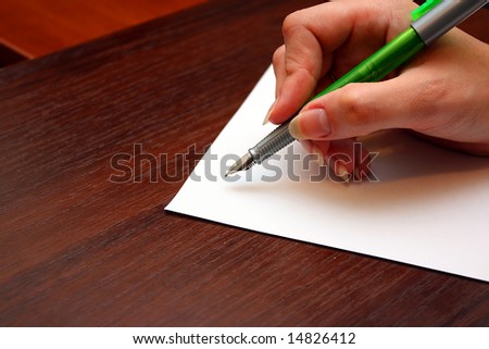 Hand with pen writing a letter