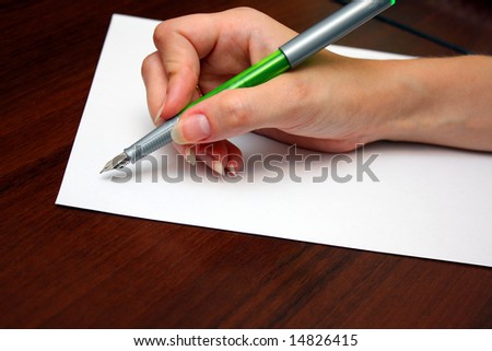 Hand with pen writing a letter