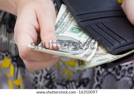 Hand with dollars and purse