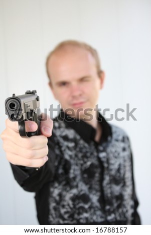 Young man aiming with pistol in hand