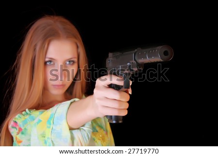 Attractive girl aiming with gun on black background