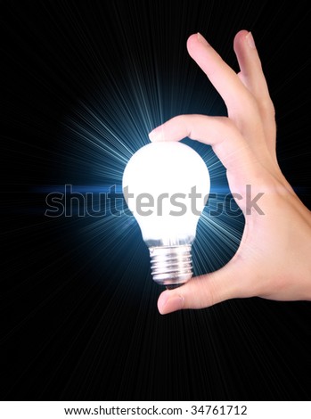 bright incandescent bulb in hand isolated on black background