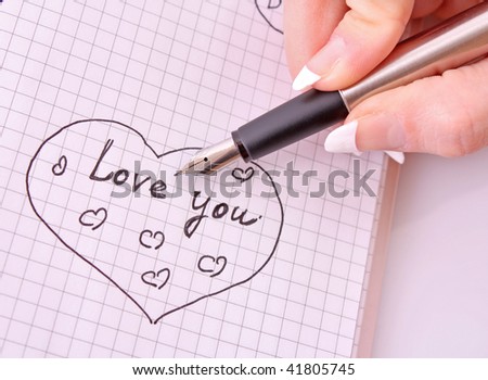 Hand with pen writing a love letter