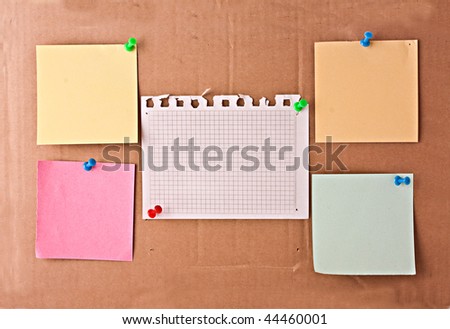 Four blank color memo and white memo with colourful pins on cardboard