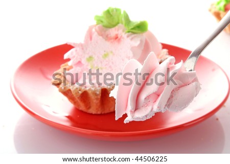 Pink cheesecake with maraschino cherry on the plate