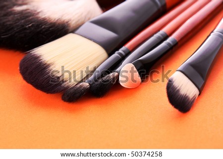 cosmetic brushes on the orange background