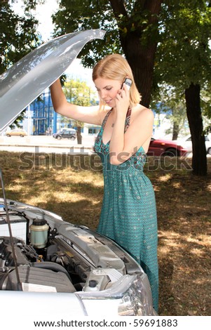 Young blonde woman in her car breaks down.