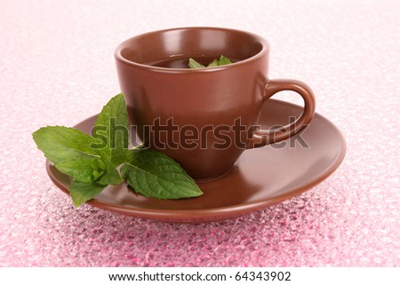 Cup of green tea on the saucer with mint