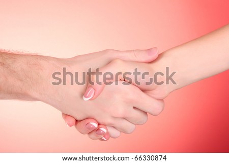 handshake between man and woman on red background
