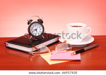 Cup of coffee, book, clock and calculator on wooden table - stock 
