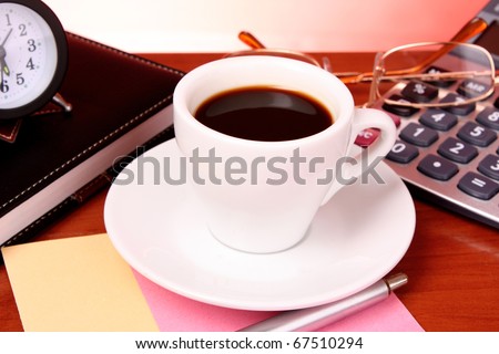Cup of coffee, book, clock and calculator on wooden table