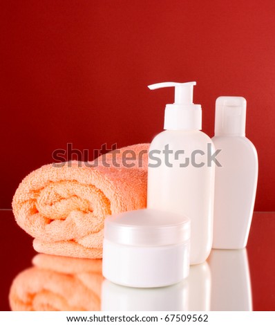 bottles of health and beauty products on red background